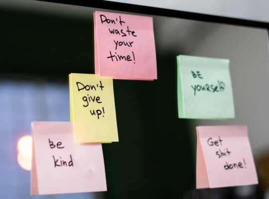 Colorful sticky notes with motivational messages on a mirror reflecting positivity.